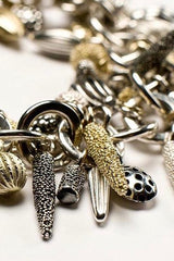 Close up of Mixed Pod Cluster Bracelet hung with lots of charms inspired by seed pods