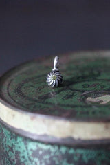 A delicate swirling gemstone charm – choose a Peridot for your August birthday.