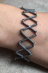 My Kiss Cross Bracelet worn in oxidised silver is a geometric design that links a row of crosses or kisses