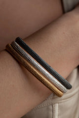 Three of my oval Dotty Bangles worn in silver, oxidised silver and gold plated silver decorated with my signature dotted texture