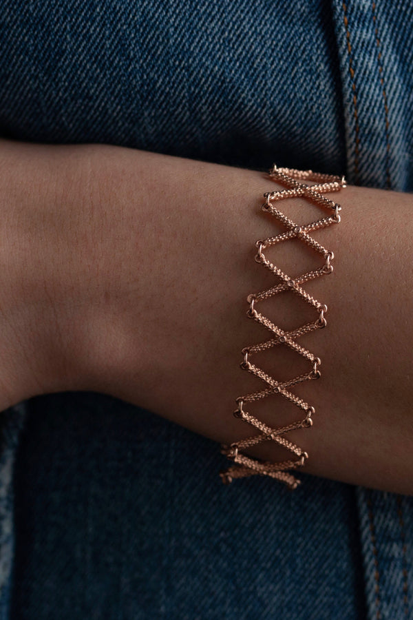 My Kiss Cross Bracelet worn in rose gold plated silver is a geometric design that links a row of crosses or kisses
