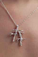 My unusual branch pendant worn by a model is set with a Red Garnet January's birthstone hangs from a delicate trace chain