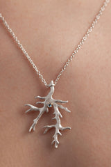 My branch pendant worn by a model is set with March's birthstone Aquamarine hangs from a delicate trace chain