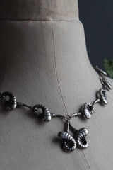 My Snake Necklace, inspired by the Harry Potter Slytherin Snake and Flobberworm, features crossed curling snakes