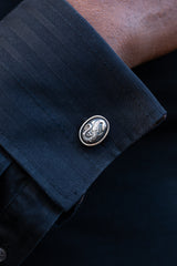 Chunky silver cufflinks with an intricate snake motif as their centrepiece.