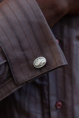 Chunky silver cufflinks with an intricate snake motif as their centrepiece.