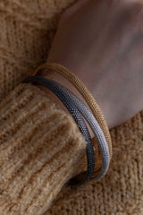 Three of my oval Dotty Bangles worn in silver, oxidised silver and gold plated silver decorated with my signature dotted texture