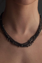 My Five Strand Trace and Pip Necklace worn triple wrapped comprises five delicate oxidised silver chains, decorated with miniature bright silver plated pips