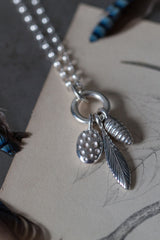 Short pendant necklace with a cluster of 3 charms inspired by seed pods and feathers for nature lovers