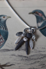 Close up of my Dream Catcher Feather Pendant necklace, hung with nine charms inspired by the shape of feathers and seed pods, that's sure to appeal to nature lovers