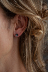 These unusual stud earrings feature small cups which are striated with rhythmic lines that draw the eye.