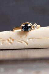 A one off Blue Spinel in 18ct yellow gold cup setting with a white diamond on 18ct yellow gold band