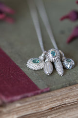 A dainty pendant featuring a cluster of 5 silver pollen charms on a fine trace chain 3 set with Alexandrite June's birthstone