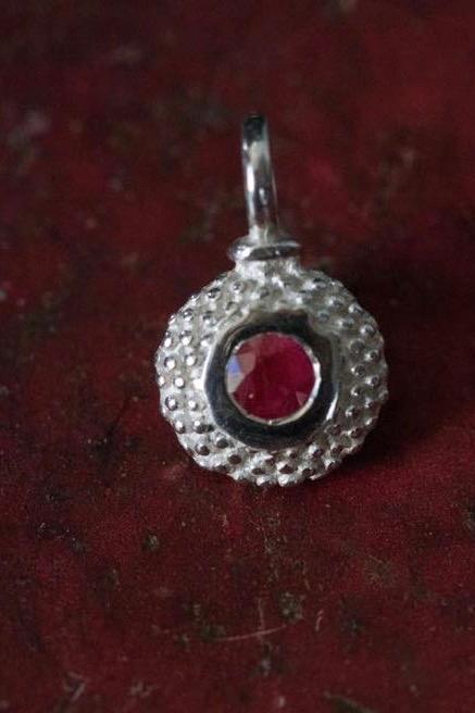 A bobbled pollen charm in silver with a ravishing ruby, July's birthstone.