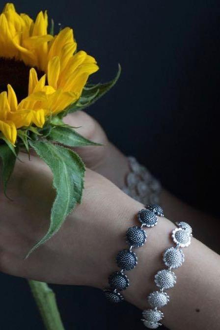 Pair of my Sunflower Bracelets worn in silver and oxidised silver features 13 double sided sunflower beads 