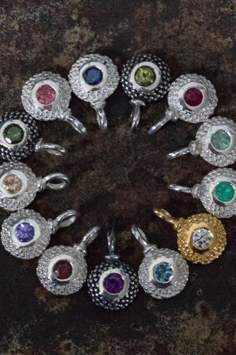 Close up of a circular set of bobbled pollen birthstone charms.