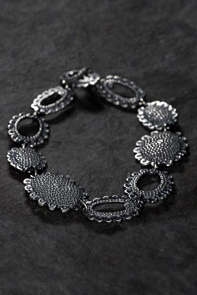 close up of Baroque Bracelet with 9 highly decorative oval discs to create a modern classic