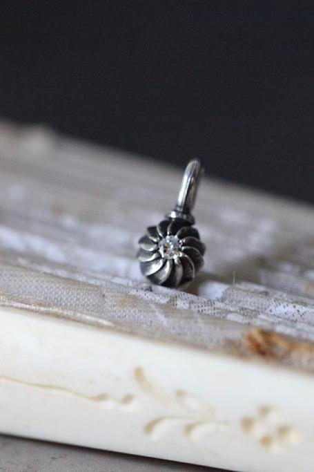 A delicate swirling gemstone charm – choose a Diamond for your April  birthday. 