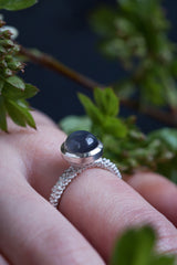 My Moon Ring worn by a model has a bobbled shank set with 8mm cabouchon grey moonstone
