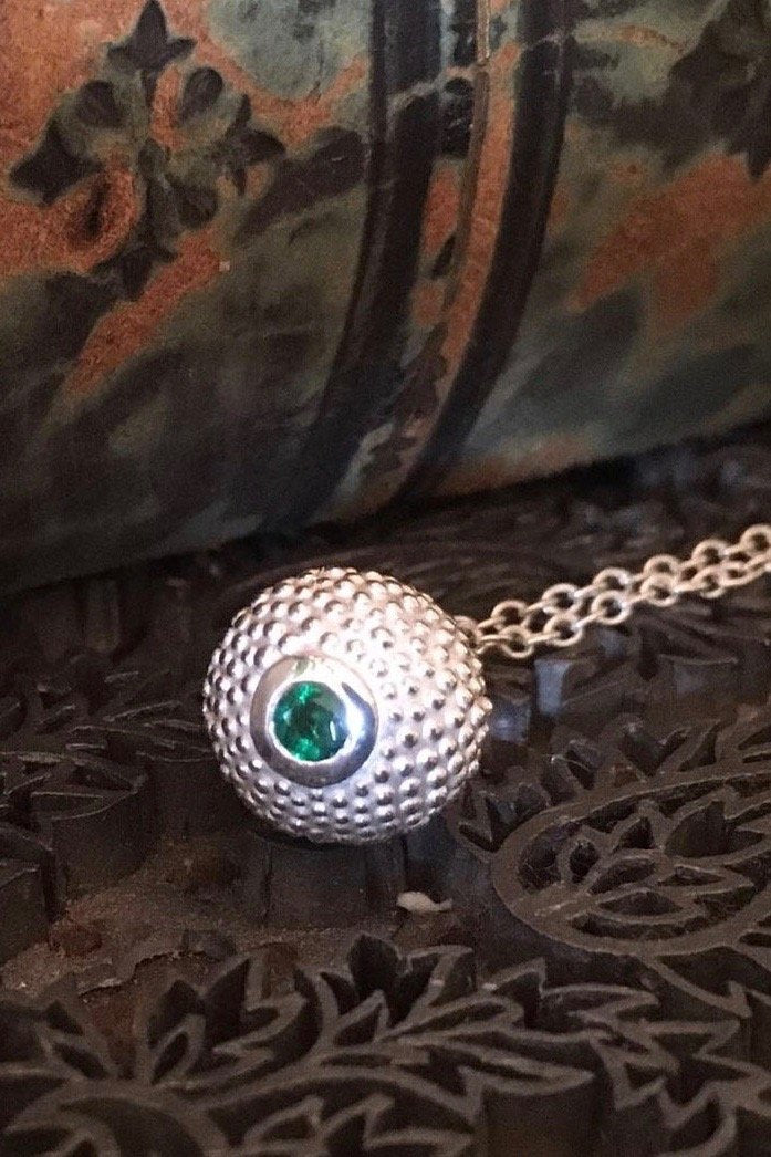 A special May birthstone pendant in silver – a tactile textured ball with a glistening Emerald at the base