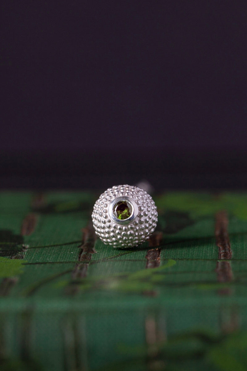 A birthstone pendant for October – a tactile textured ball with a glistening Green Tourmaline at the base