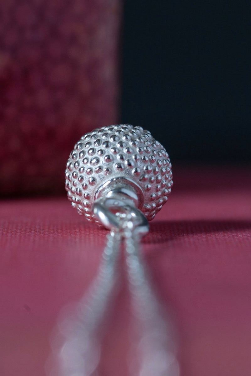 Close up of the top of my special birthstone pendant for October in silver – its centrepiece is a tactile textured ball with a glistening Pink Tourmaline at the base
