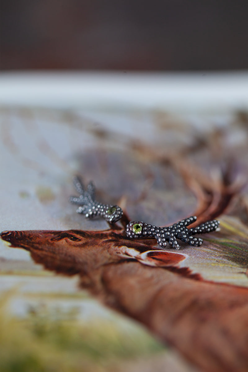 A textured earring, with a shape reminiscent of an antler which sits along the ear lobe