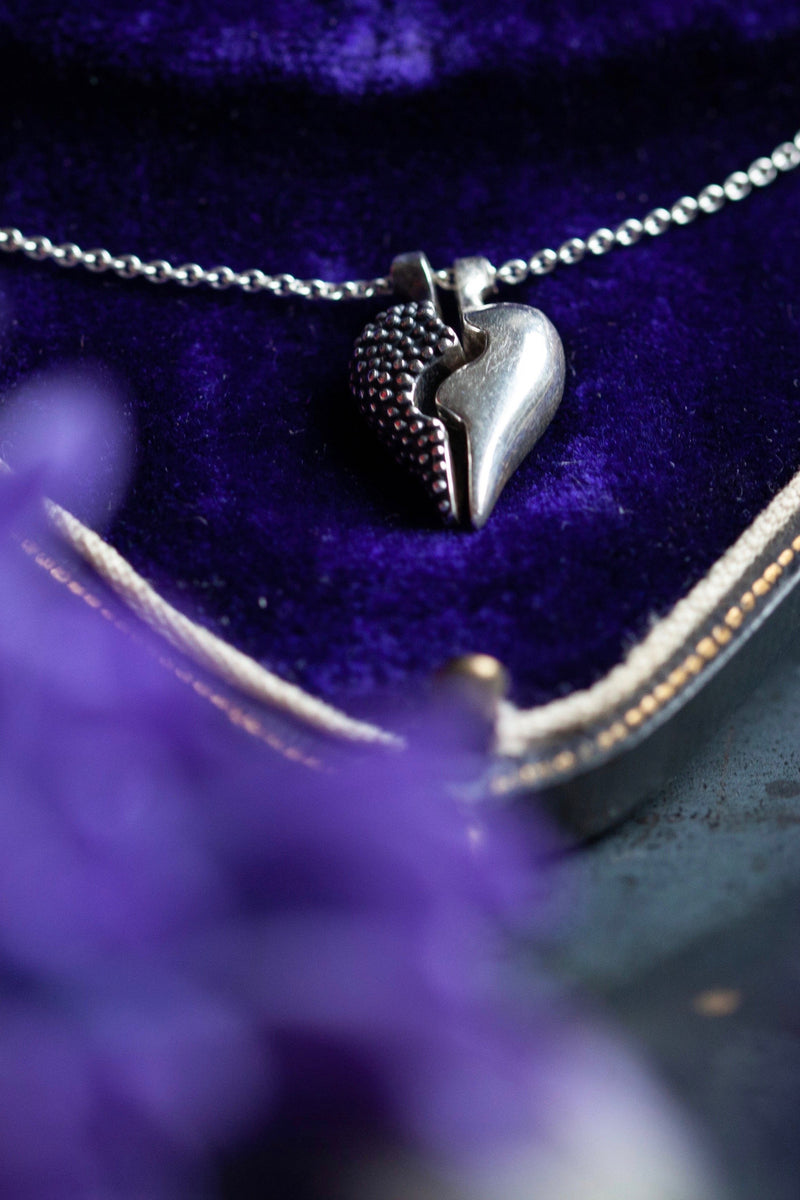 Dainty heart shaped pendant in two separate halves that together make one on a trace chain