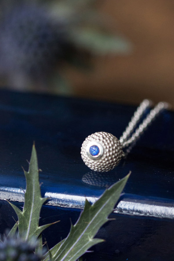 A birthstone pendant for September – a tactile textured ball with a glistening blue Sapphire at the base