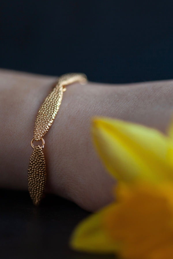 Model wearing my Petal Bracelet with seven gold plated silver textured petals linked in a chain 