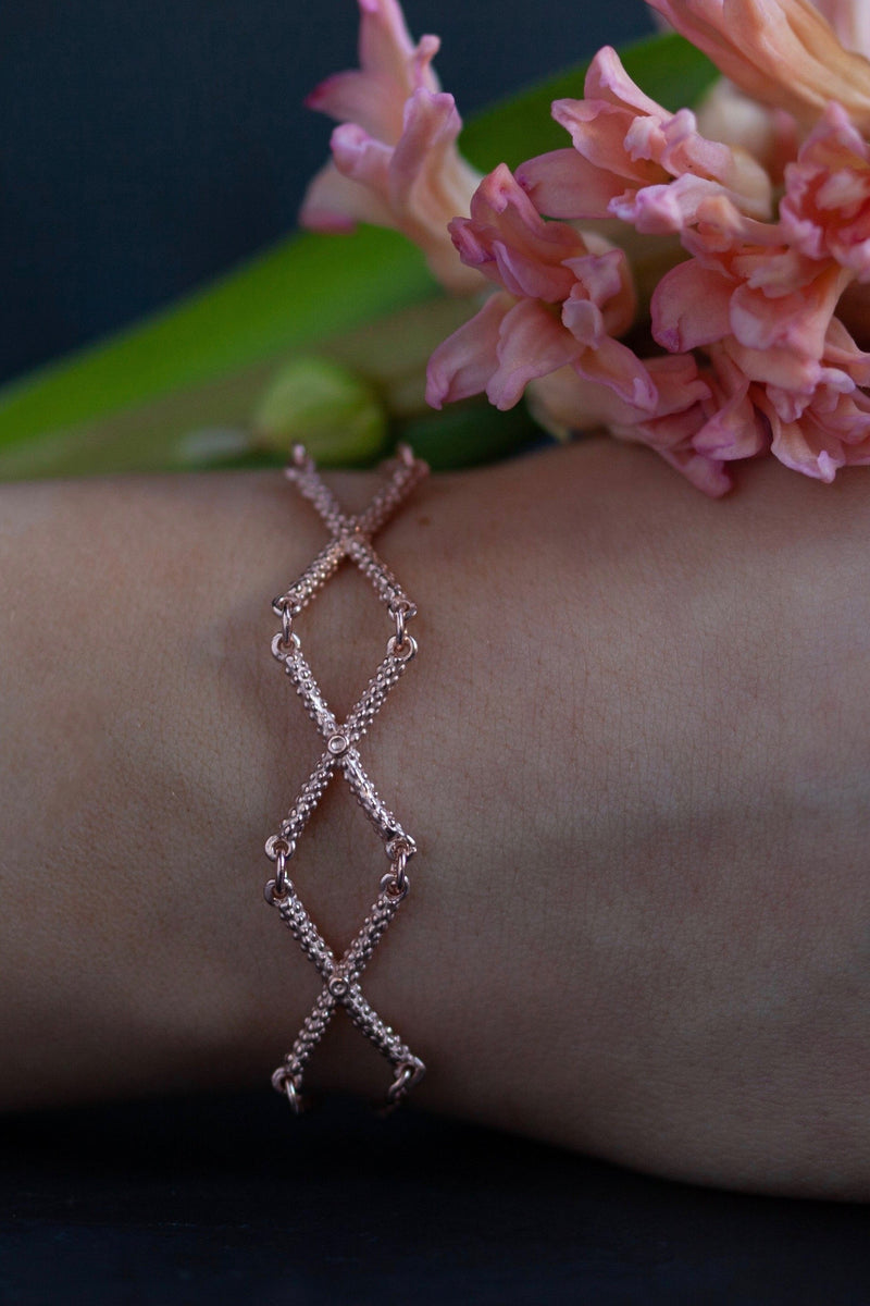 My Triple Kiss Cross Bracelet worn in rose gold plated silver features 3 crosses or kisses linked on a simple chain