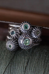 A set of 5 stacking rings featuring pollen charms each set with an Alexandrite June's birthstone