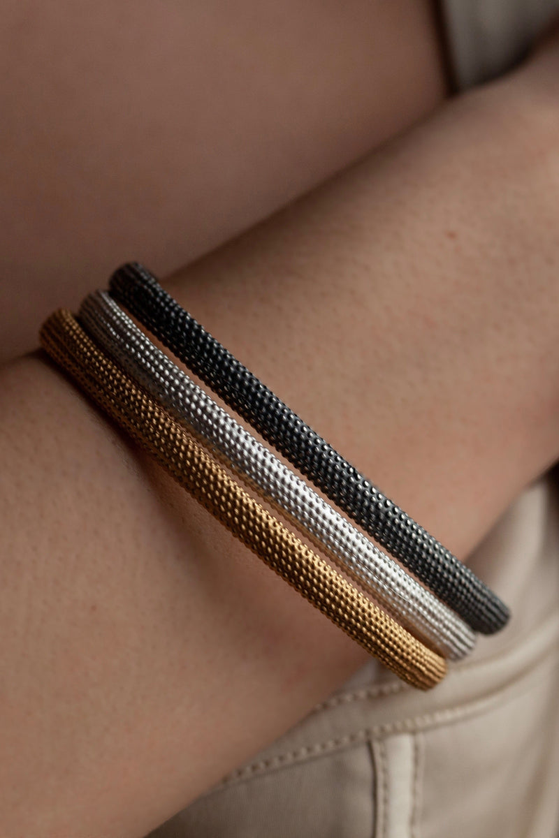Three of my oval Dotty Bangles worn in silver, oxidised silver and gold plated silver decorated with my signature dotted texture
