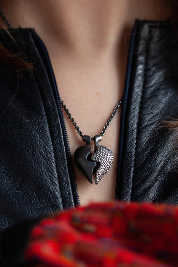 Chunky heart shaped pendant worn in oxidised silver has two separate halves that together make one