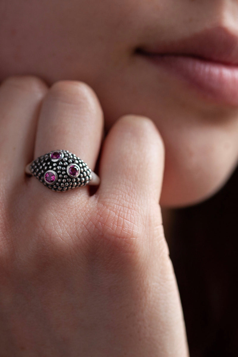 My Cobra Ring worn by a model is silver beaded and set with 3 pink garnets