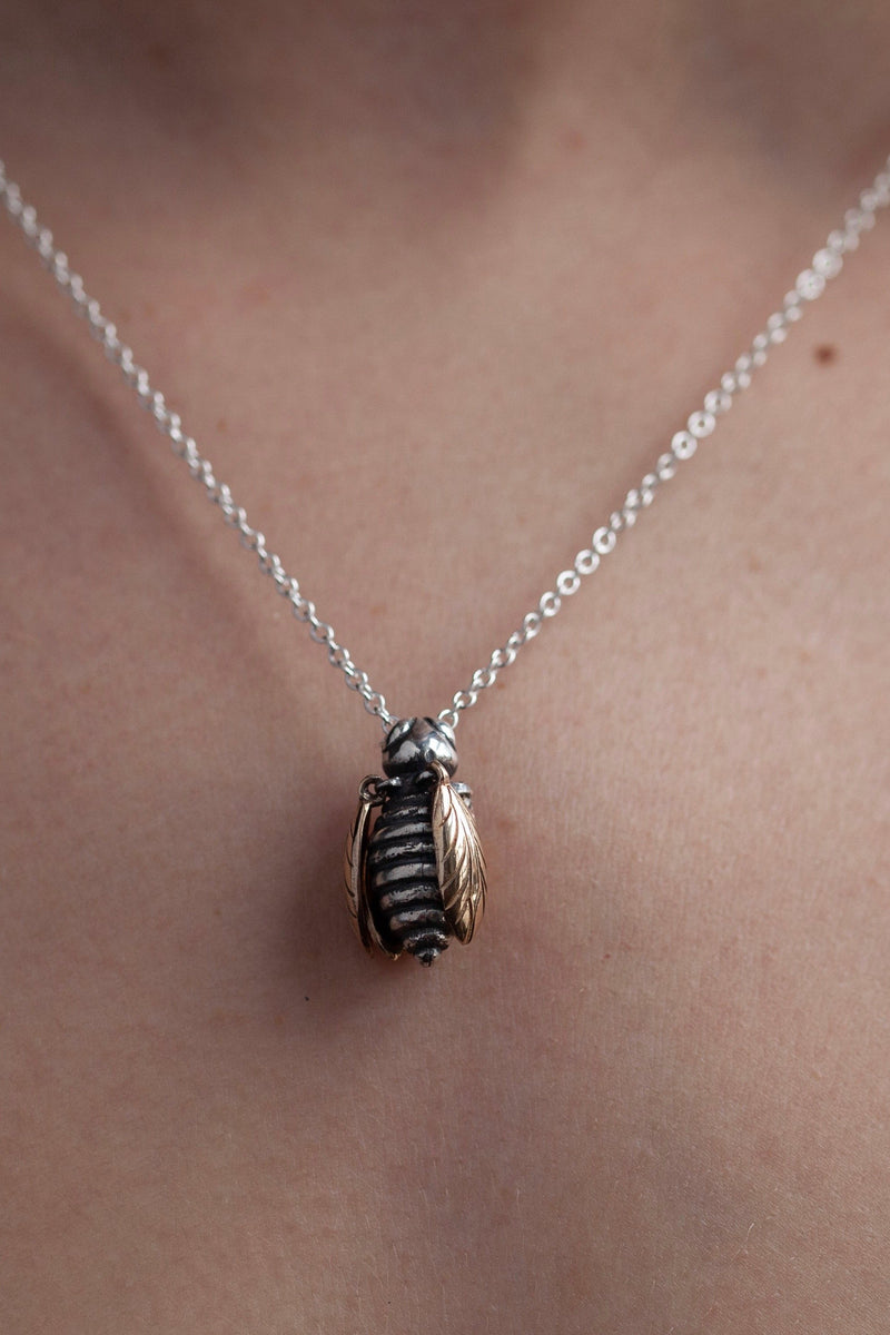 My Tiny Bee necklace worn by a model with gold wings and oxidised silver body 