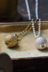 A pair of birthstone pendants for November – a tactile textured ball with a glistening Yellow Topaz at the base