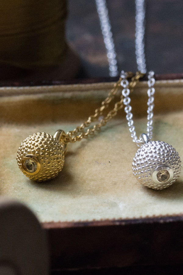 A pair of birthstone pendants for November – a tactile textured ball with a glistening Yellow Topaz at the base