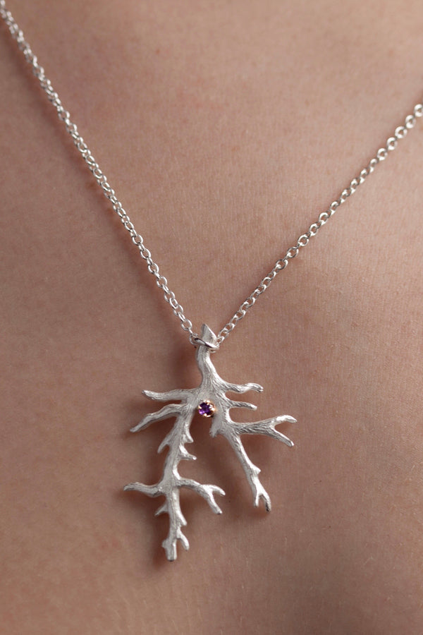 My unusual branch pendant worn by a model, set with an Amethyst, February's birthstone, hangs from a delicate trace chain that can be worn at two lengths