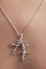 My branch pendant worn by a model is set with March's birthstone Aquamarine hangs from a delicate trace chain 