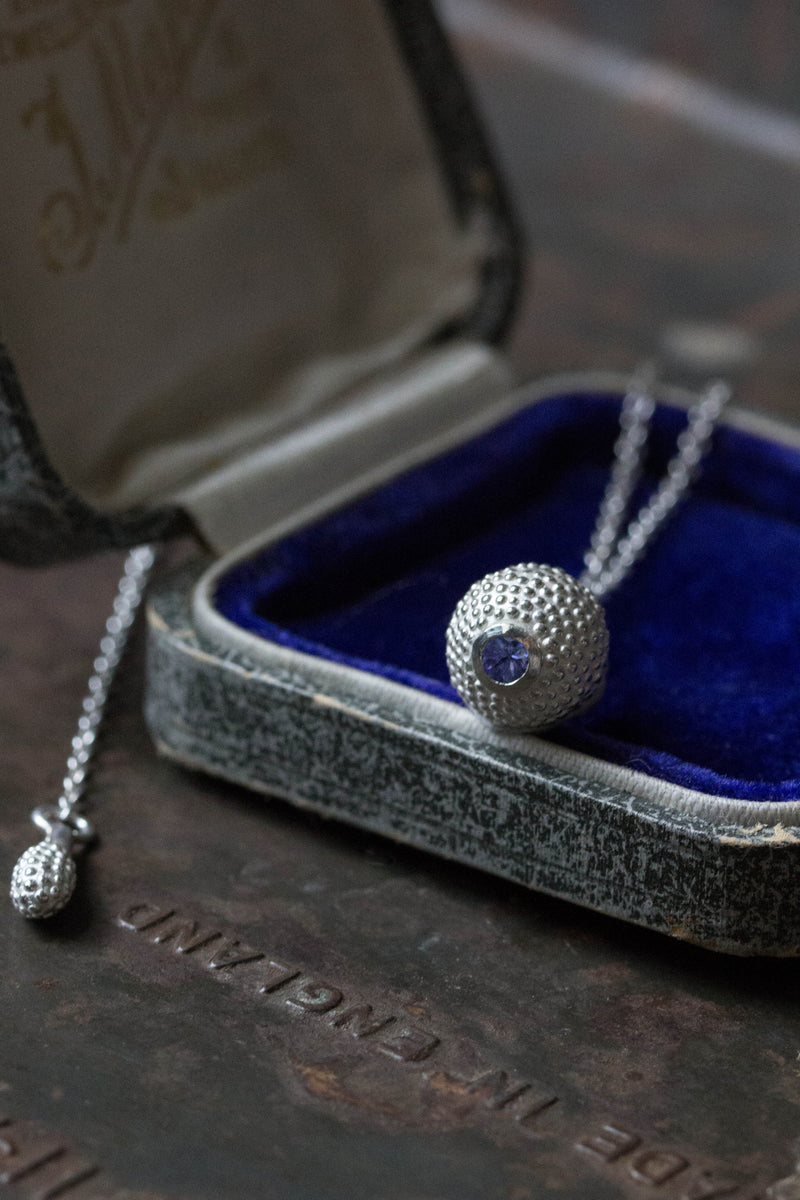 A special birthstone pendant for December in a jewellery box – its centrepiece is a tactile textured ball with a glistening Tanzanite at the base.