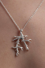 My unusual branch pendant worn by a model, with a London Blue Topaz November's birthstone, on a delicate trace chain