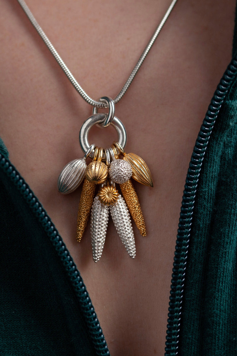 My Spot the Nine Pod Cluster Pendant worn on silver chain is hung with a bold charm pendant