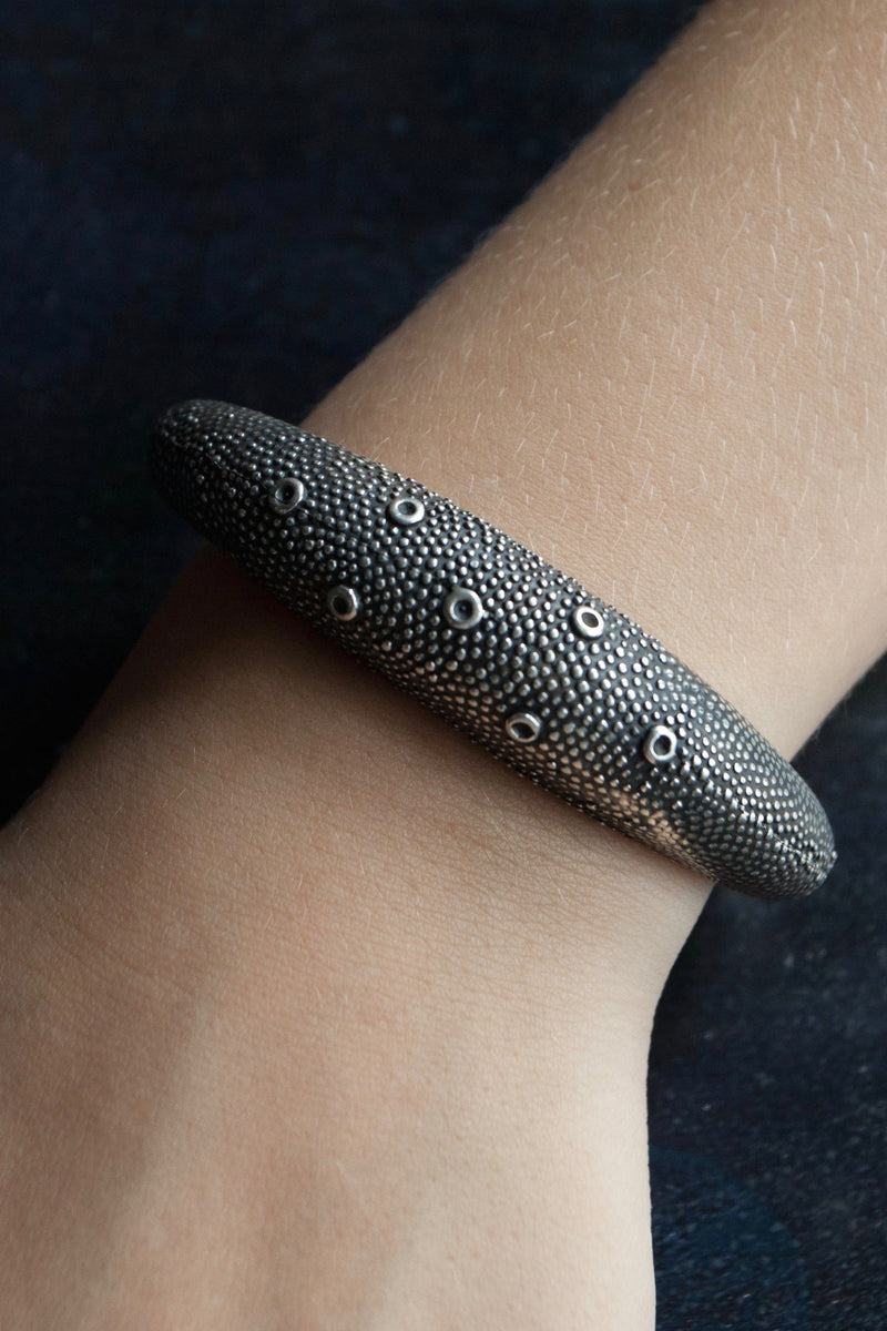 My Axolotl cuff bangle worn in oxidised silver is decorated with my signature bobble texture that catches the light