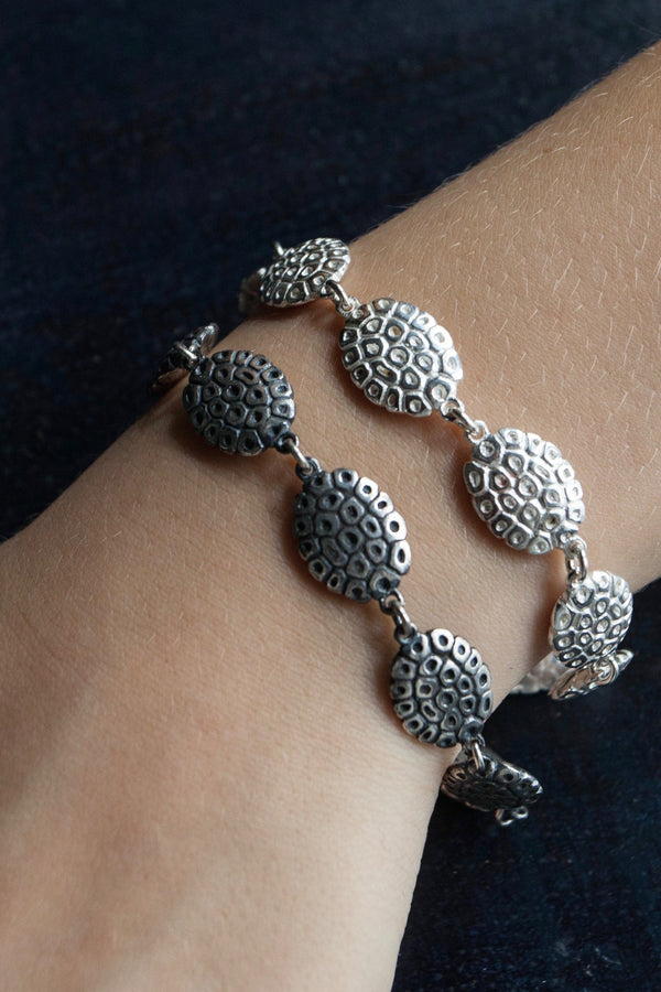 Pair of my Turtle Bracelet worn in silver and oxidised silver formed from 9 double sided beans inspired by turtle shells