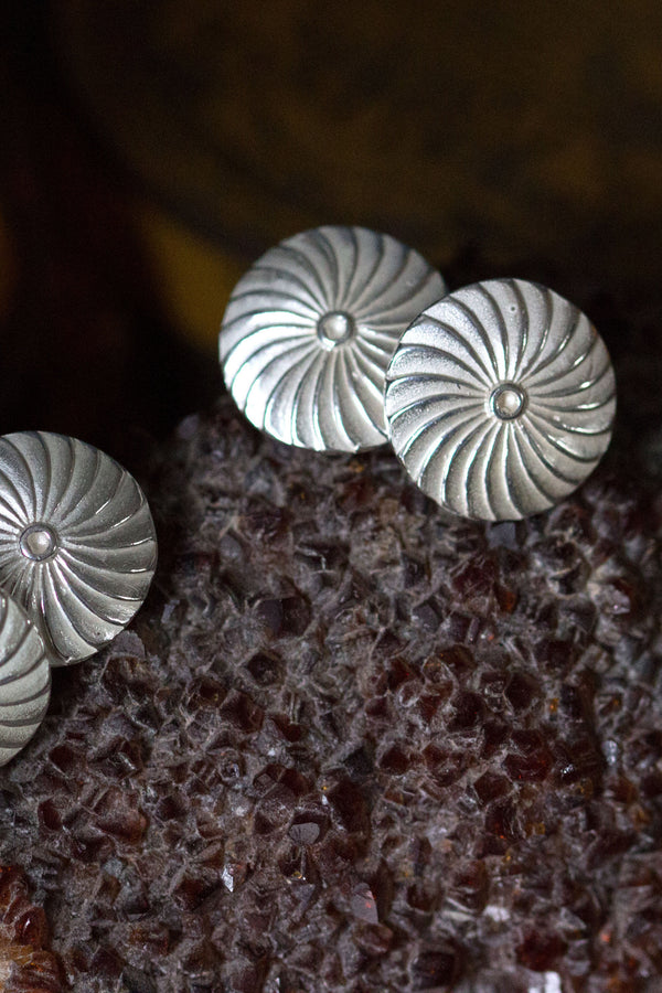 My Catherine Wheel cufflinks feature circular faces with a swirling ridged texture joined with chain links