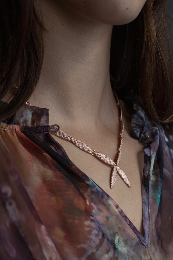 My Petal Necklace worn by model links textured petals into a chain with two petals creating a focal point