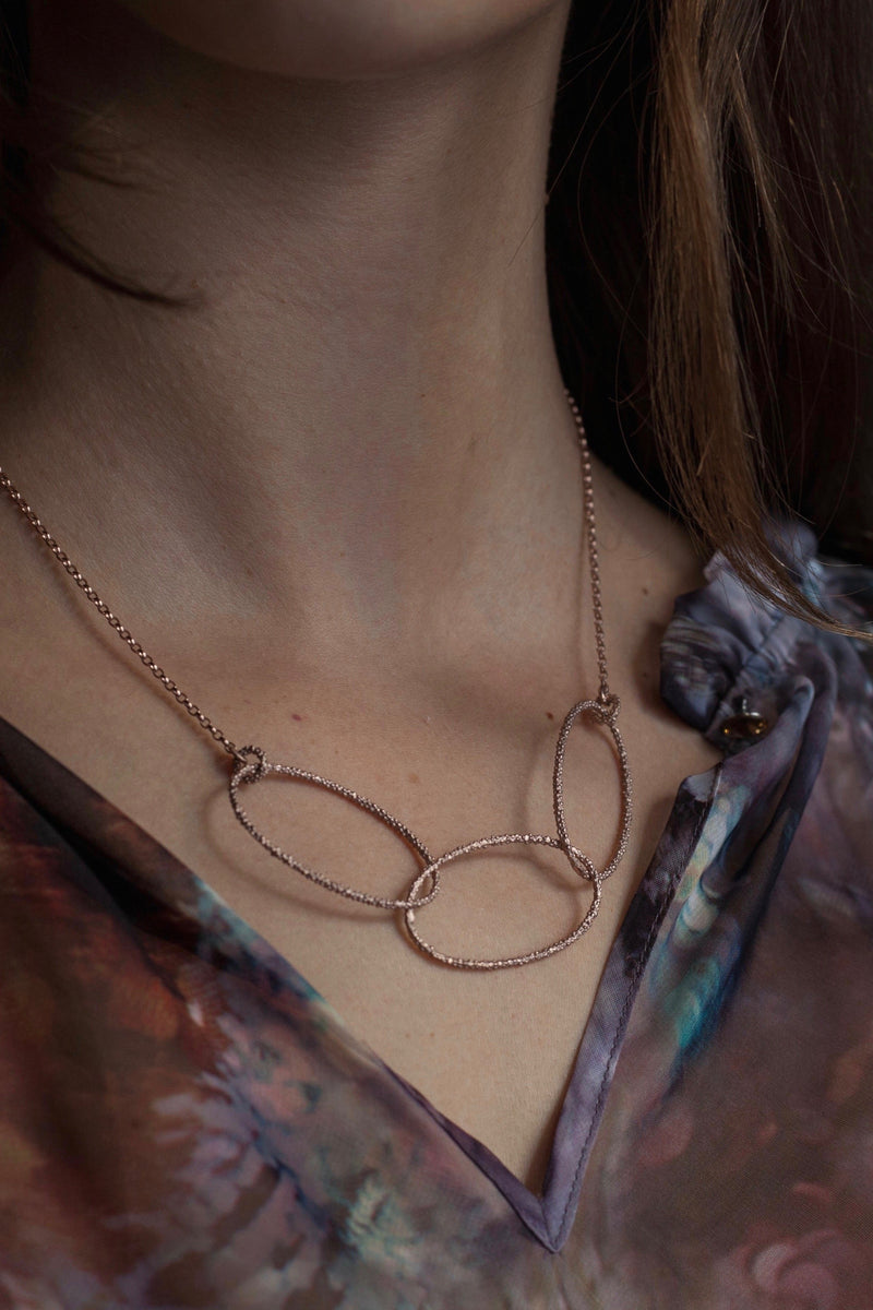 My Triple Oval Bobbled Hoop necklace worn by a model with 3 interlocking oval hoops in rose plated gold