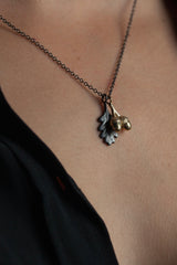 My Twin Acorn and Oak Leaf pendant worn by a model has a pair of acorns hanging in front of a delicate oak leaf