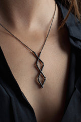 My Kiss Cross Necklace worn by a model is a geometric design formed from linked crosses or kisses
